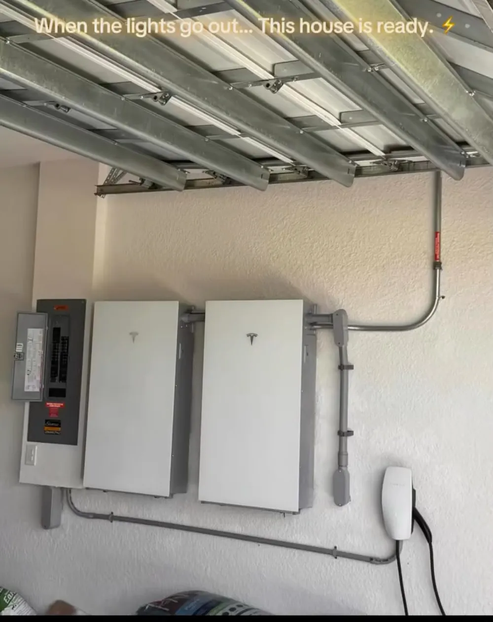 Two home backup batteries and a main panel installed in a garage by Switch It Up Electric in Southwest Florida