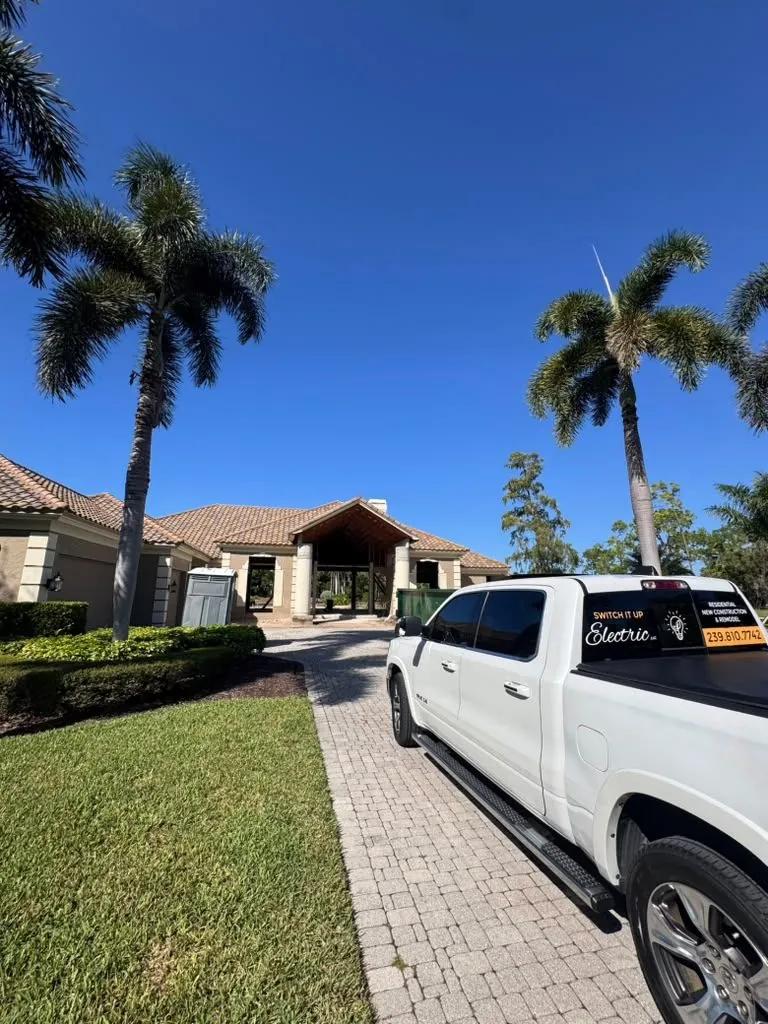Switch It Up Electric truck with decal and phone number parked in a paver driveway at a new construction home in Southwest Florida